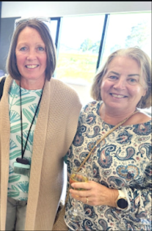 Four women posing together in an indoor setting