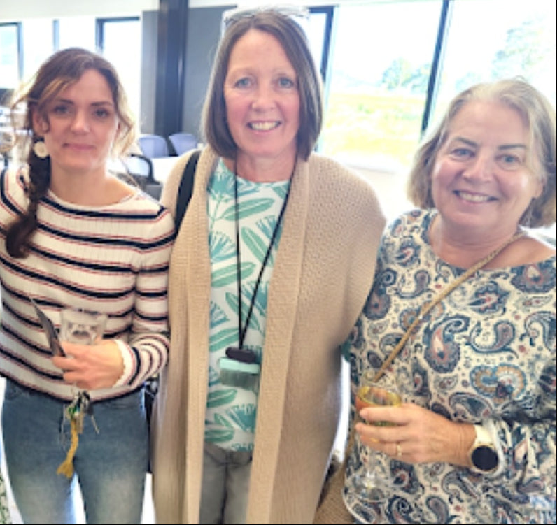 Four women posing together in an indoor setting