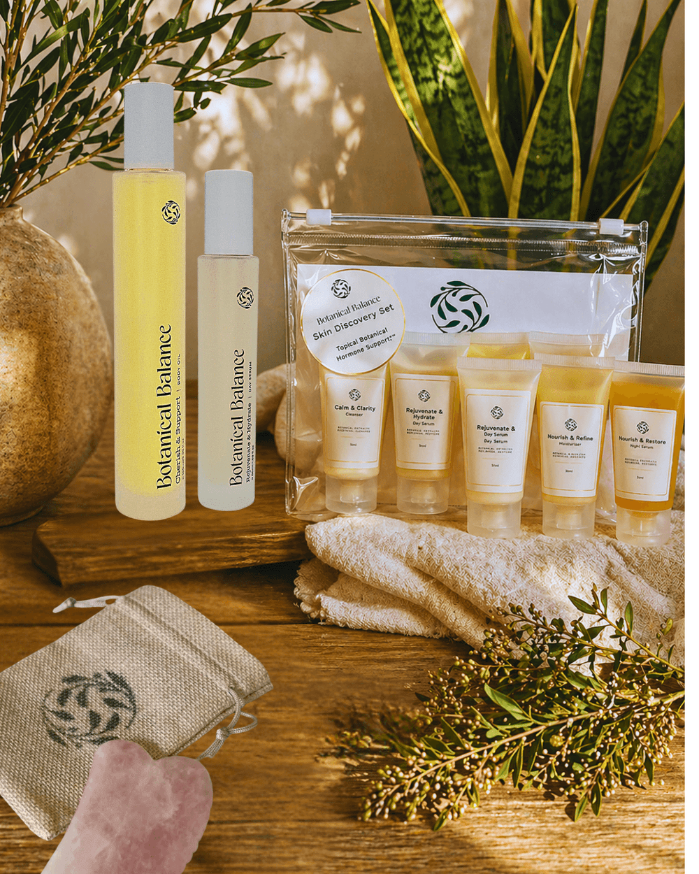 Botanical Balance products including bottles and a package on a wooden surface with plants in the background.